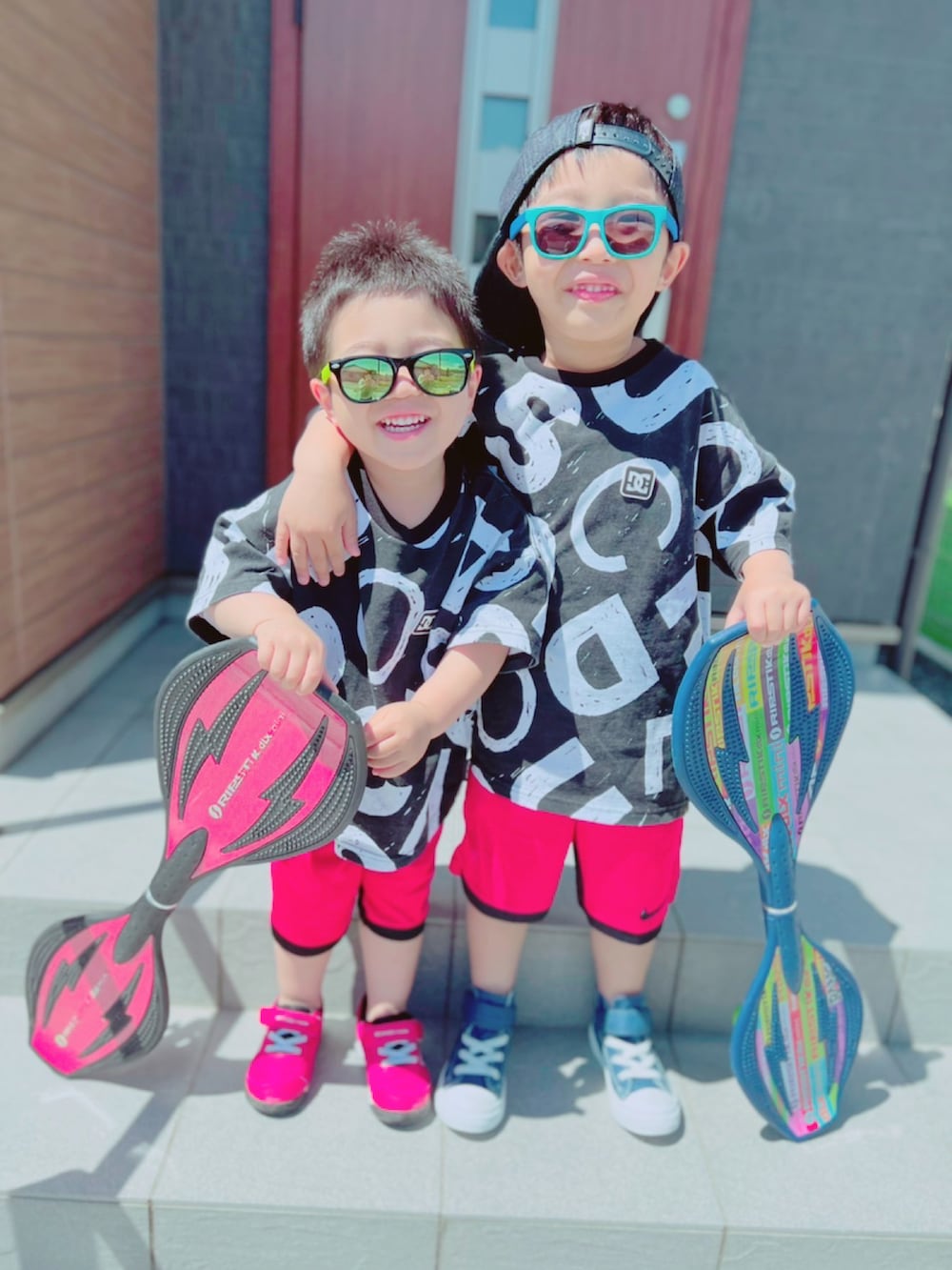 レッド系のスニーカー、ブルー系のスニーカー、ブラック系のTシャツ/カットソーを着用したキッズの春コーディネートの2枚目の写真