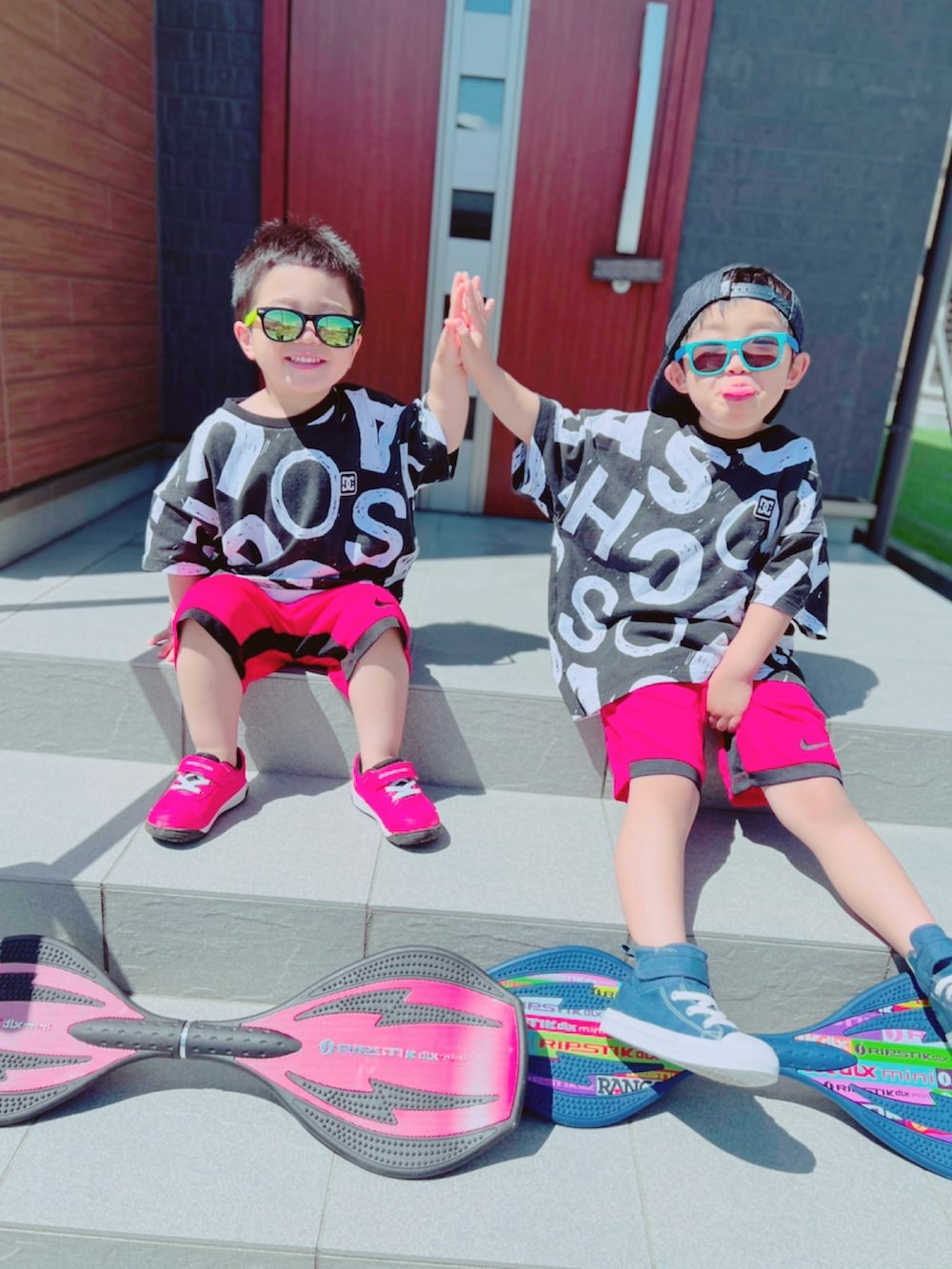 レッド系のスニーカー、ブルー系のスニーカー、ブラック系のTシャツ/カットソーを着用したキッズの春コーディネートの3枚目の写真