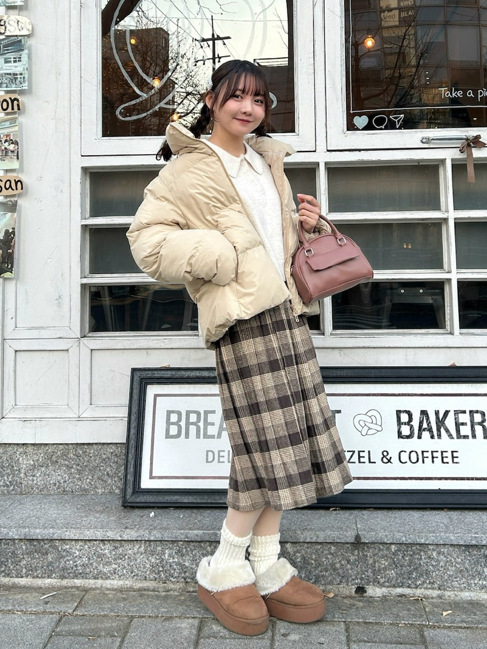 ベージュ系のジャケット/アウター、ホワイト系のニット/セーター、ピンク系のボストンバッグを着用したレディースの冬コーディネートの2枚目の写真