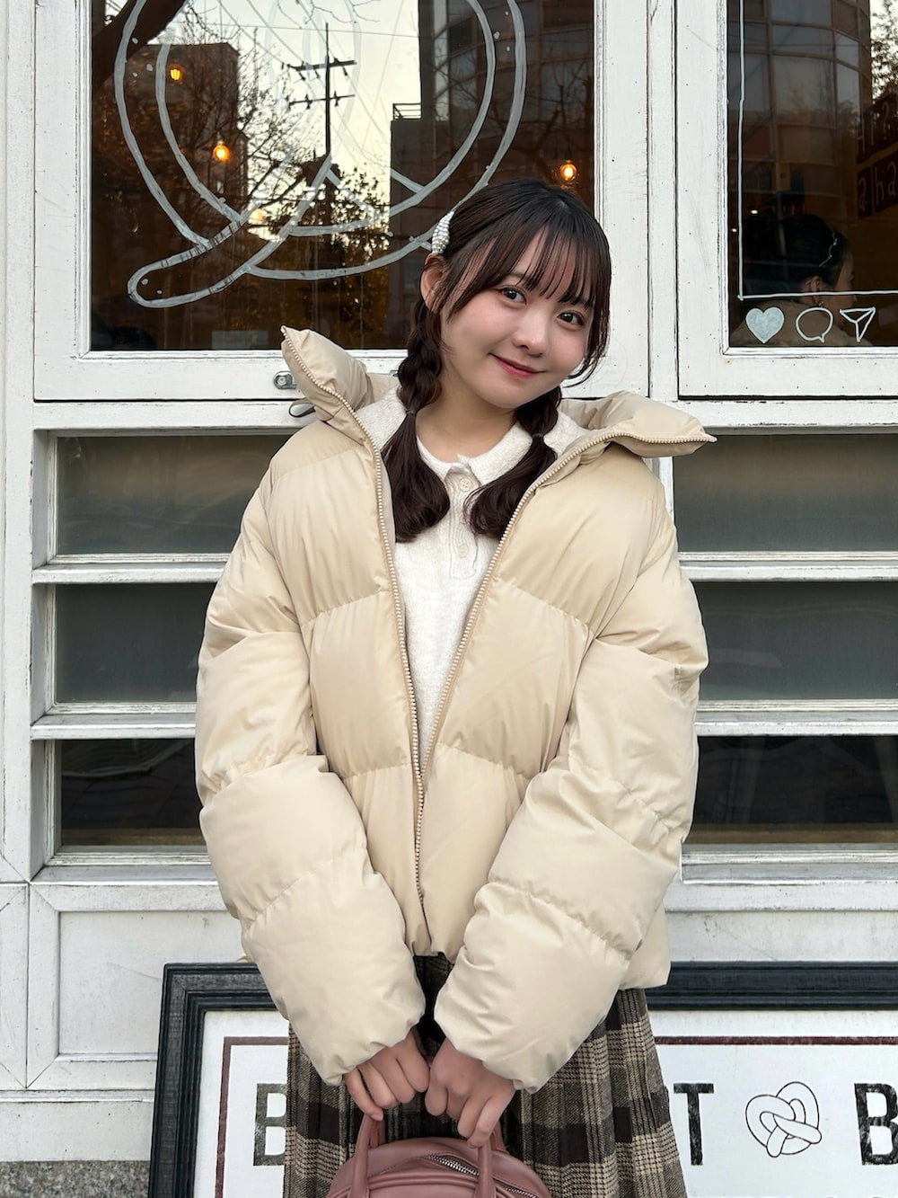 ベージュ系のジャケット/アウター、ホワイト系のニット/セーター、ピンク系のボストンバッグを着用したレディースの冬コーディネートの4枚目の写真