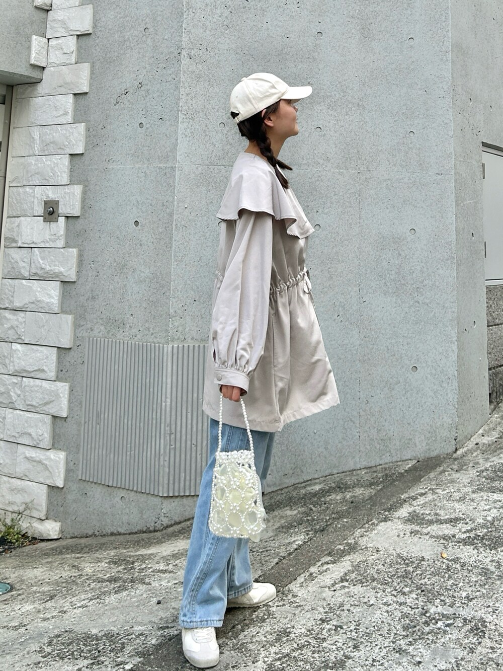 ベージュ系のジャケット/アウター、ブルー系のデニムパンツ、ベージュ系のスニーカーを着用したレディースの春コーディネートの4枚目の写真