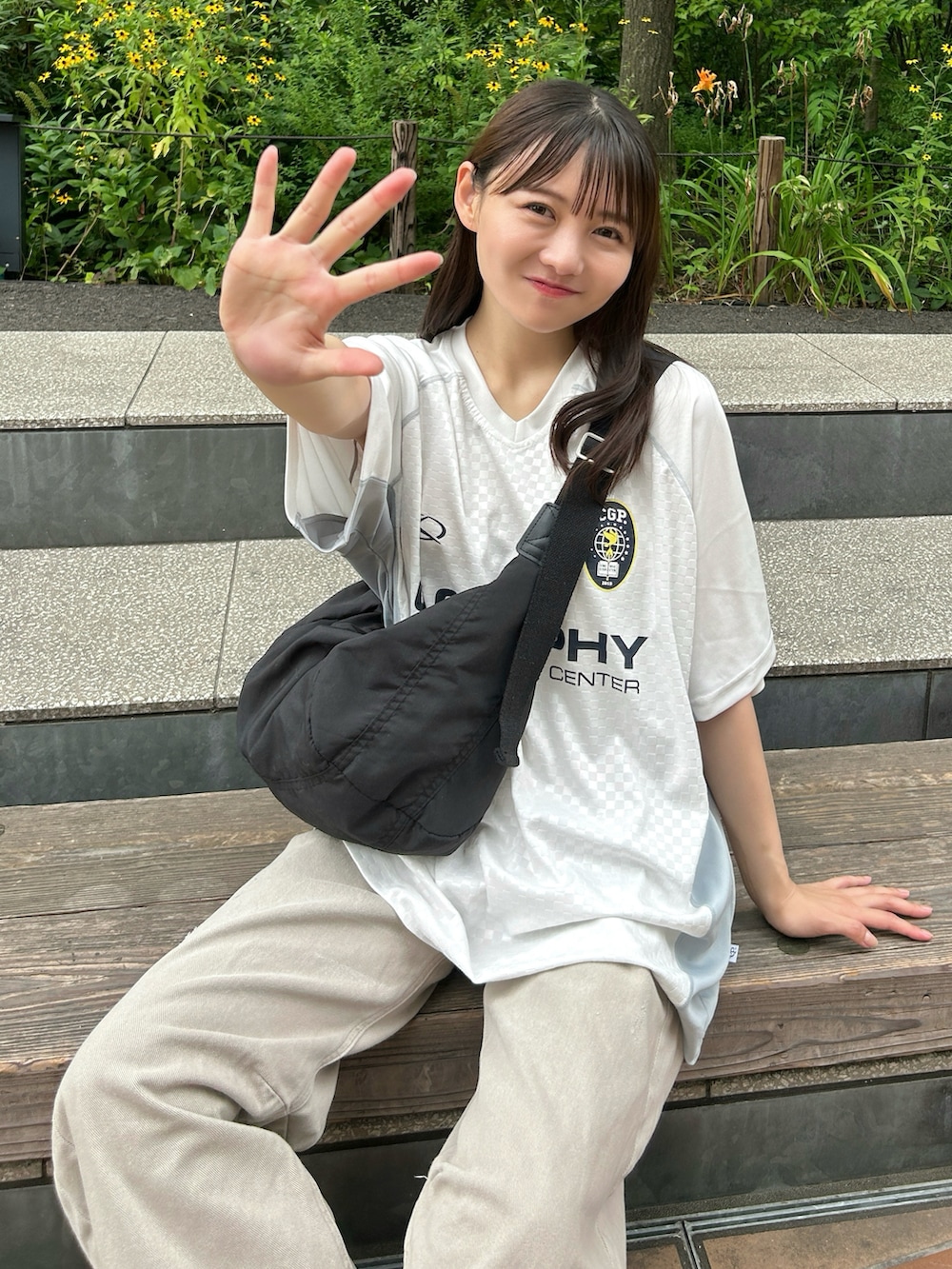 ホワイト系のTシャツ/カットソー、ブラック系のショルダーバッグ、ベージュ系のデニムパンツを着用したレディースの夏コーディネートの3枚目の写真