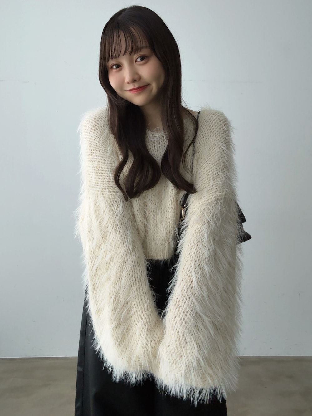 ベージュ系のニット/セーター、ブラック系のその他パンツ、ブラウン系のショルダーバッグを着用したレディースの秋コーディネートの3枚目の写真