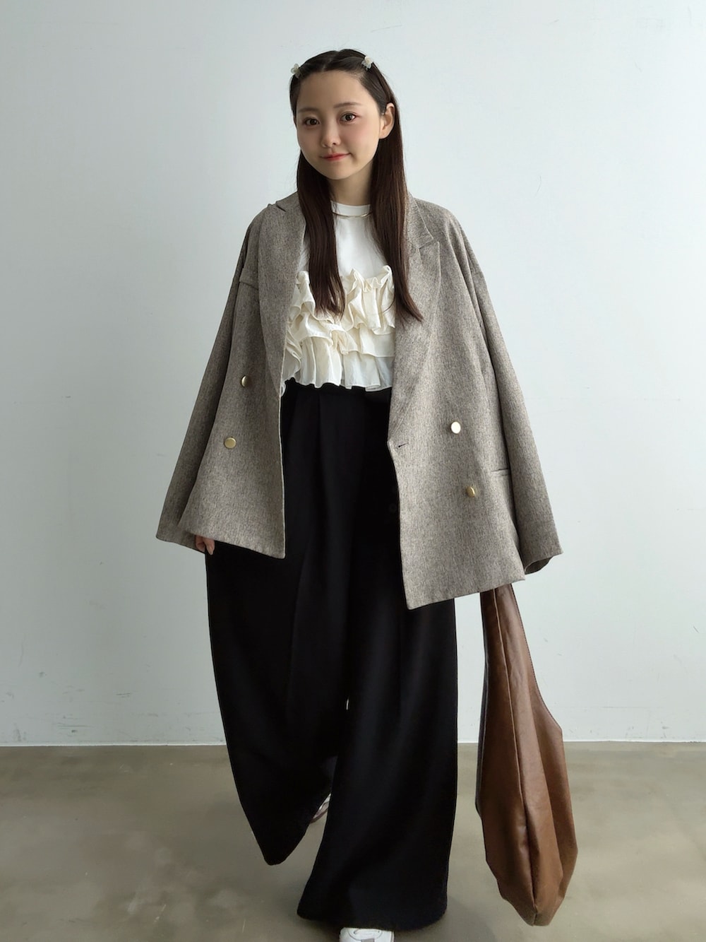 ホワイト系のTシャツ/カットソー、ベージュ系のテーラードジャケット、ブラック系のその他パンツを着用したレディースの秋コーディネートの2枚目の写真