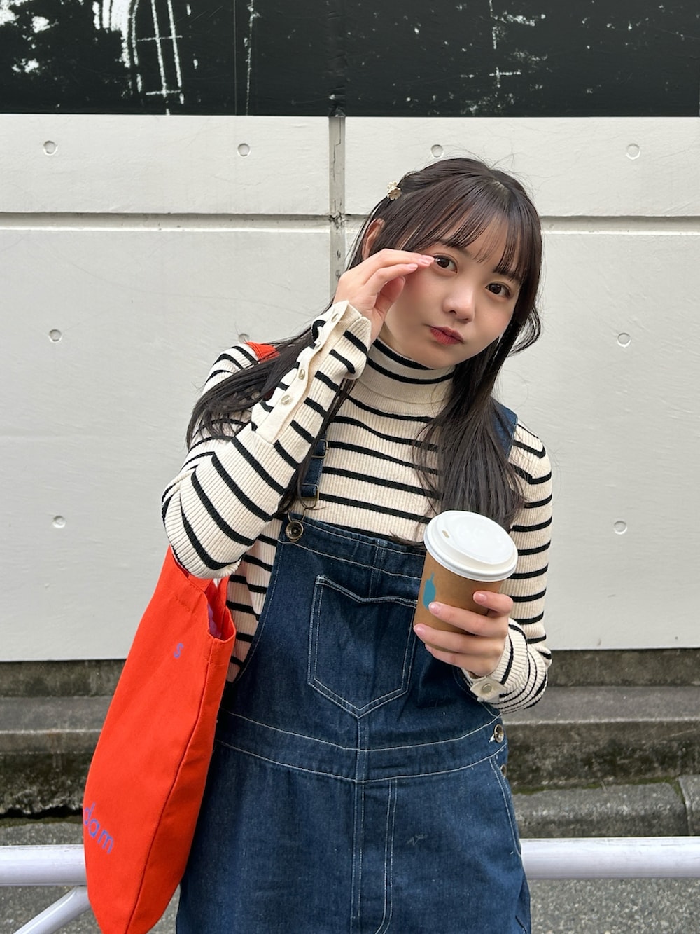 ブルー系のサロペット/オーバーオール、イエロー系のブーツ、ホワイト系のニット/セーターを着用したレディースの冬コーディネートの4枚目の写真