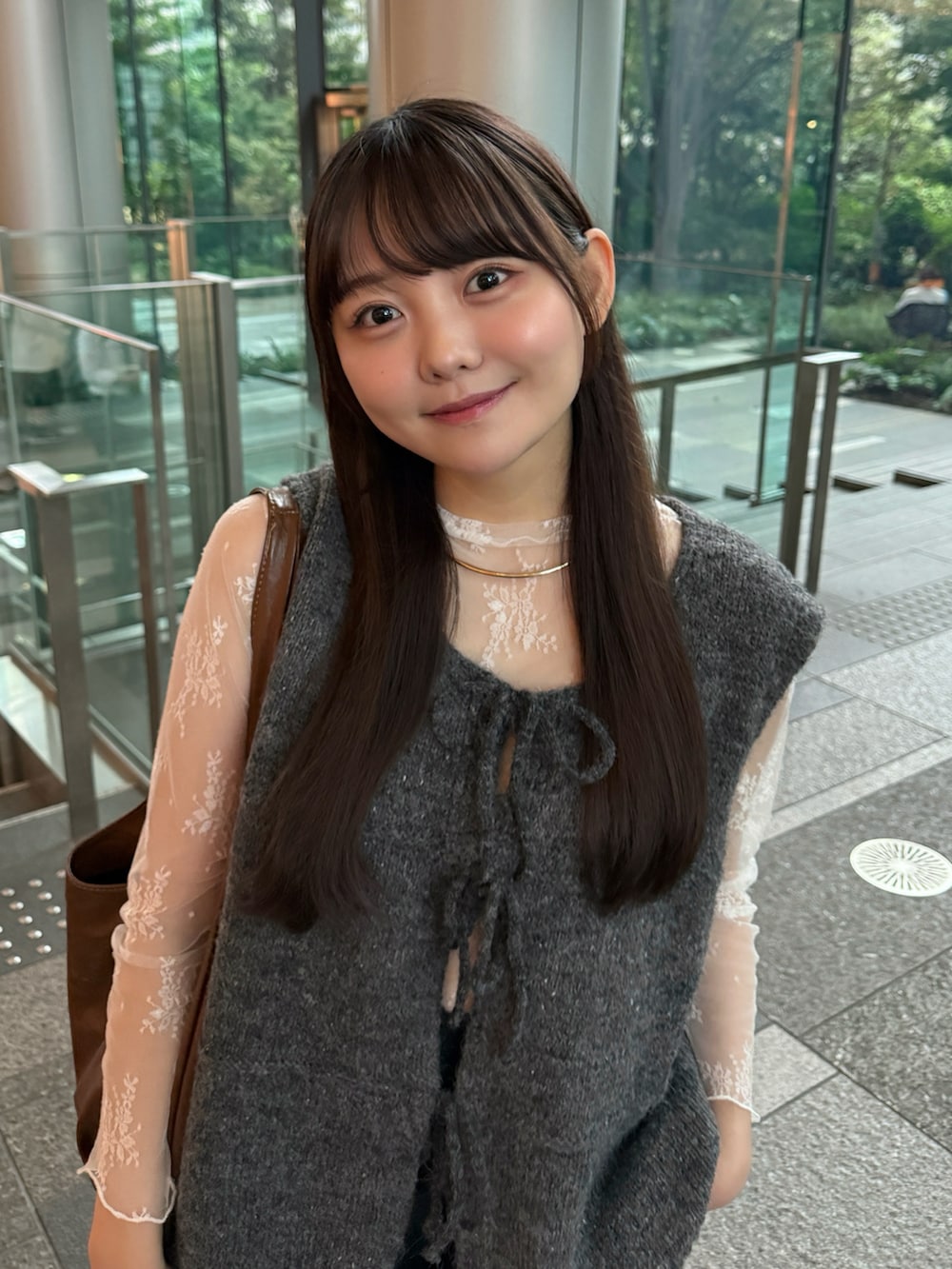 グレー系のベスト、ブラック系のその他パンツ、ホワイト系のスニーカーを着用したレディースの秋コーディネートの4枚目の写真