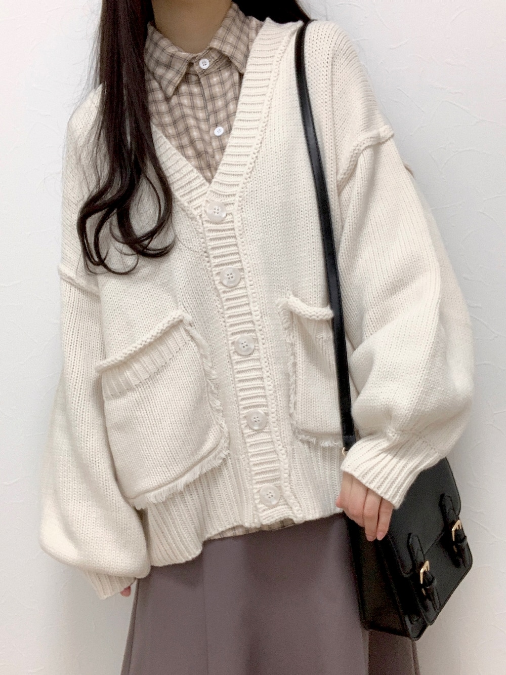 ホワイト系のカーディガン/ボレロ、ベージュ系のシャツ/ブラウス、ブラウン系のスカートを着用したレディースの冬コーディネートの2枚目の写真