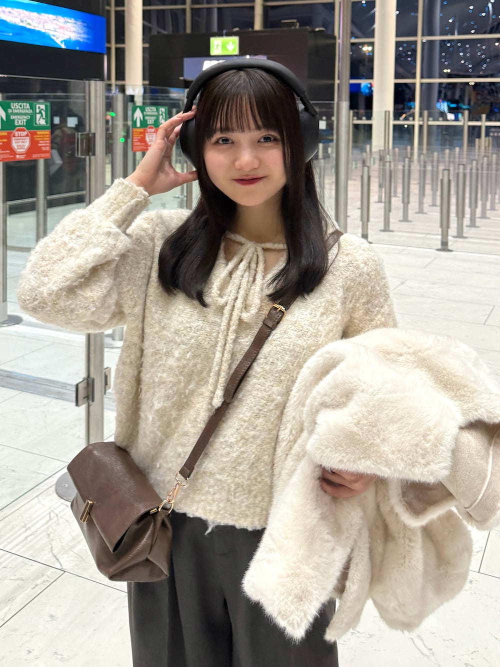 ホワイト系のブルゾン、ホワイト系のその他パンツ、グレー系のスラックスを着用したレディースの冬コーディネートの3枚目の写真