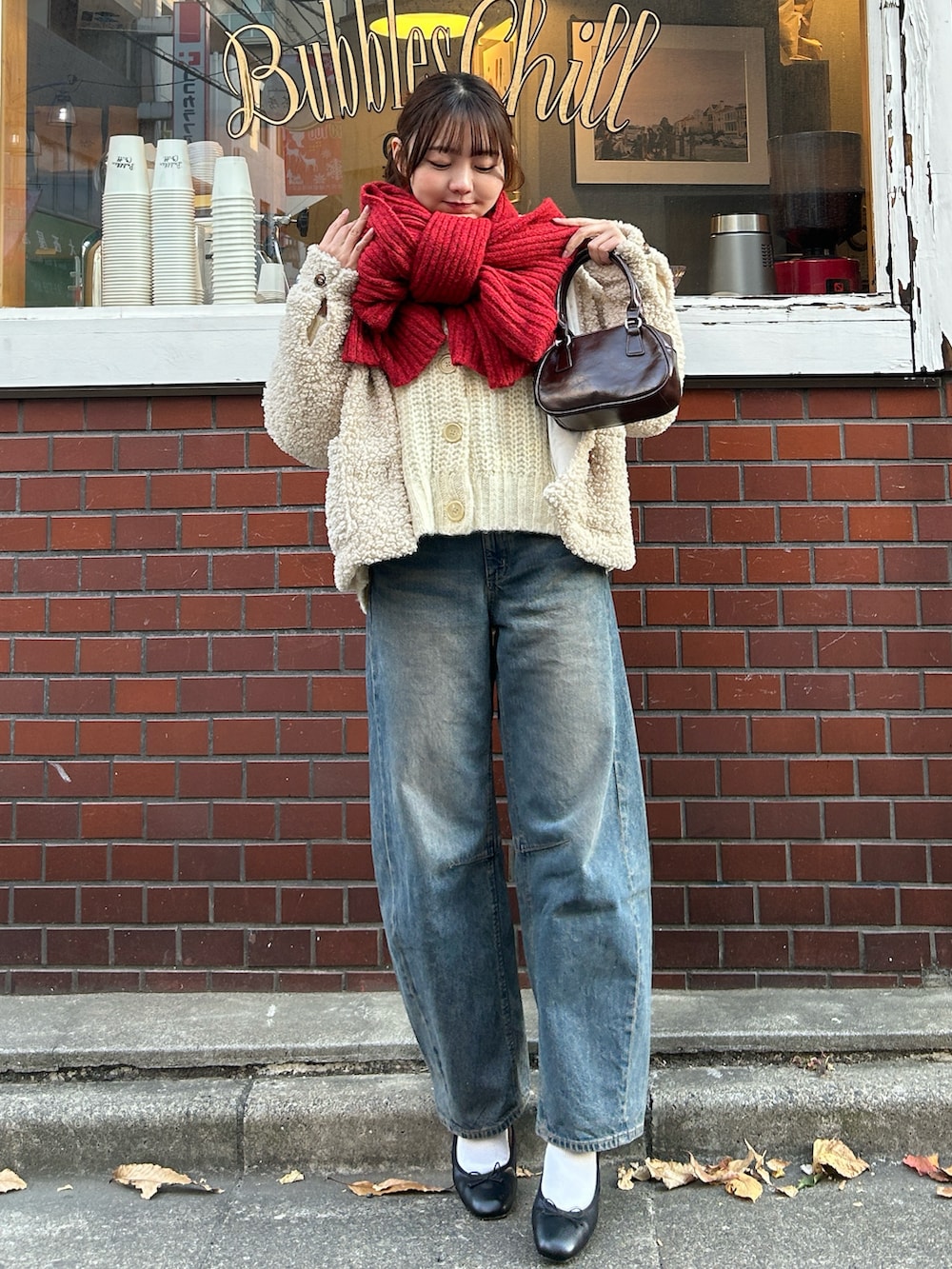 ホワイト系のカーディガン/ボレロ、ホワイト系のブルゾン、ブラウン系のハンドバッグを着用したレディースの冬コーディネートの4枚目の写真