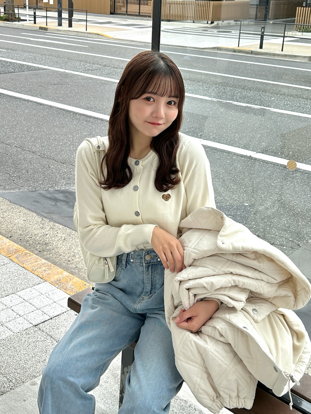 ブルー系のトップス、ブルー系のデニムパンツ、ベージュ系のスニーカーを着用したレディースの秋コーディネートの2枚目の写真