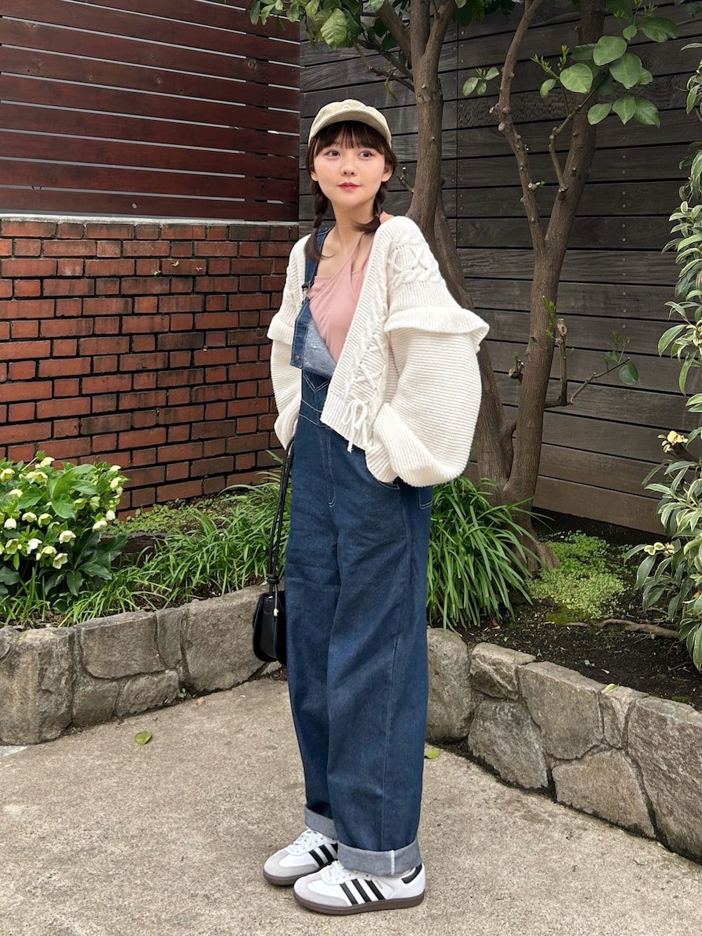 ピンク系のキャミソール、ブルー系のサロペット/オーバーオール、ホワイト系のスニーカーを着用したレディースの春コーディネートの2枚目の写真