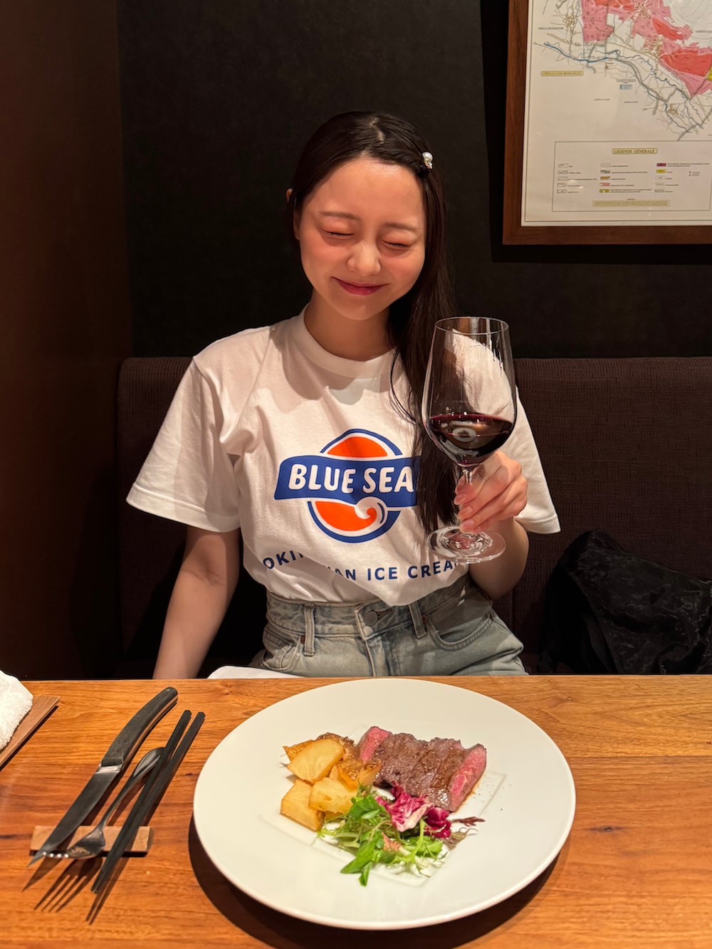 ブラック系のトートバッグ、ブラック系のサンダル、ブルー系のデニムパンツを着用したレディースの夏コーディネートの3枚目の写真