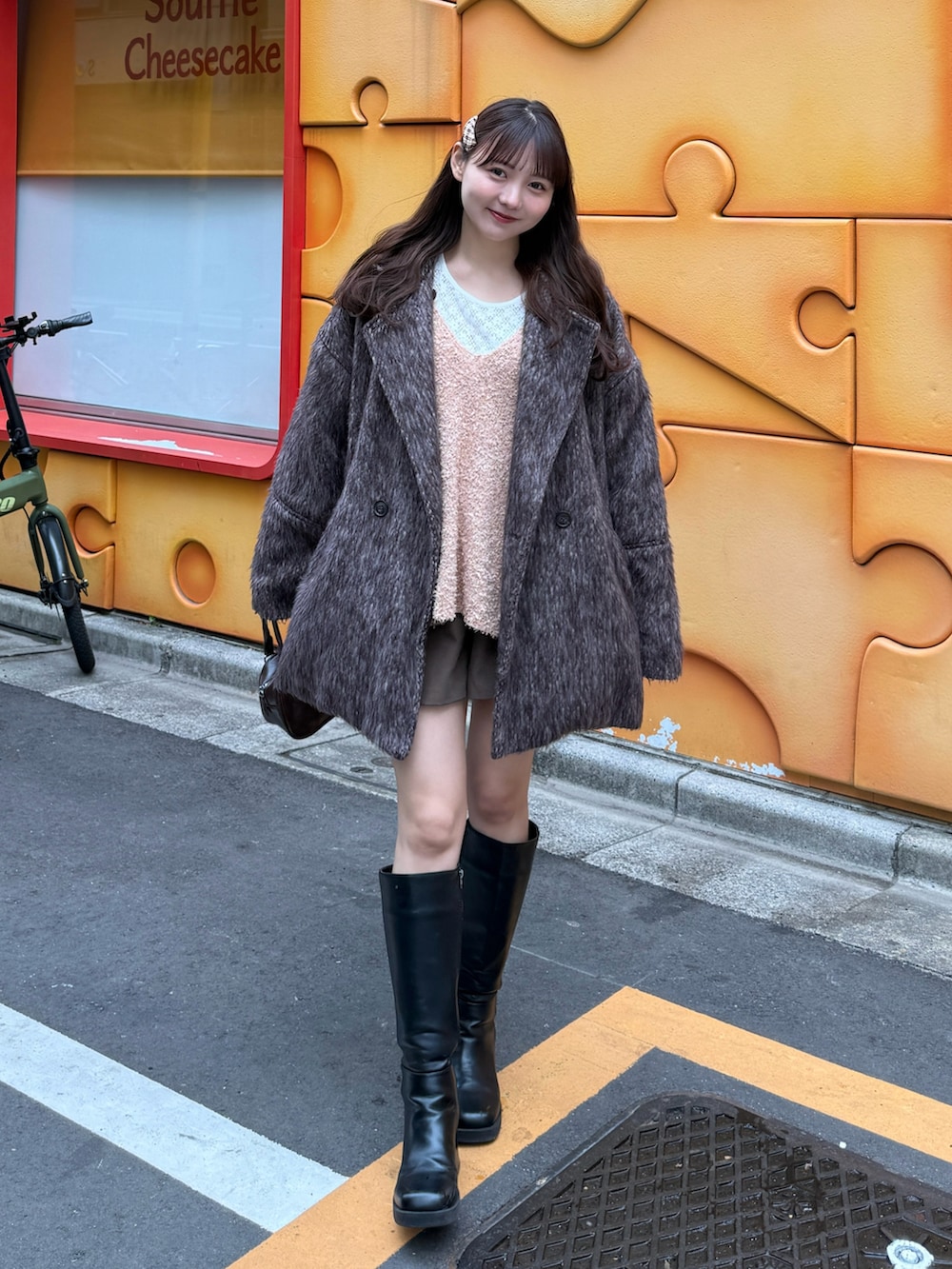 ピンク系のベスト、ホワイト系のTシャツ/カットソー、ブラウン系のハンドバッグを着用したレディースの春コーディネートの2枚目の写真