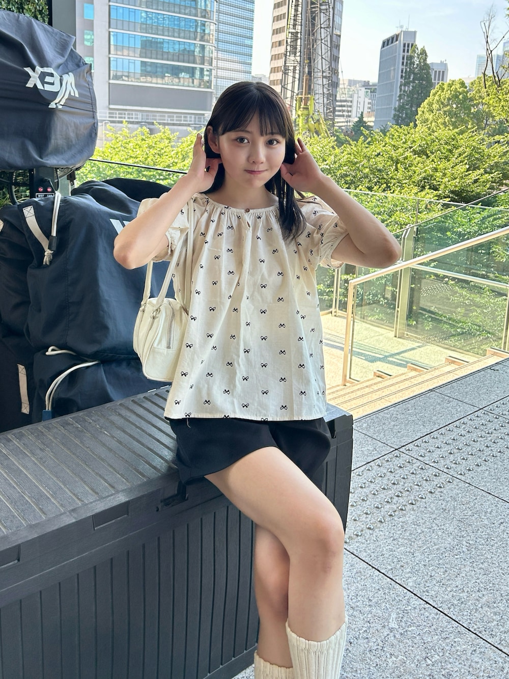 ブラック系のシャツ/ブラウス、ホワイト系のスニーカー、ホワイト系のバッグを着用したレディースの夏コーディネートの5枚目の写真