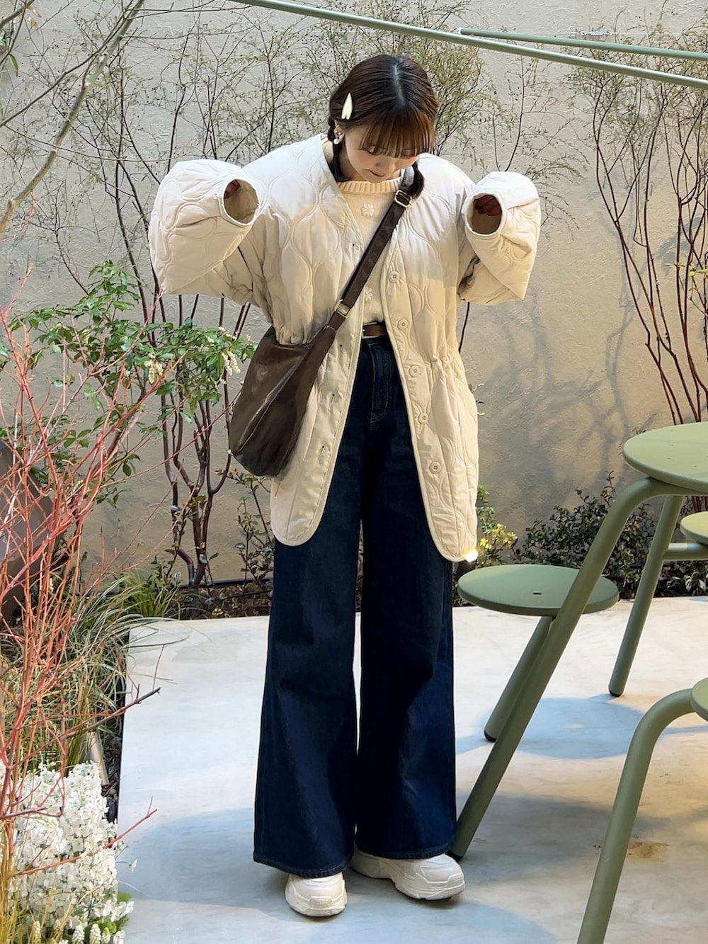 ホワイト系のノーカラージャケット、ブルー系のデニムパンツ、ホワイト系のスニーカーを着用したレディースの春コーディネートの2枚目の写真