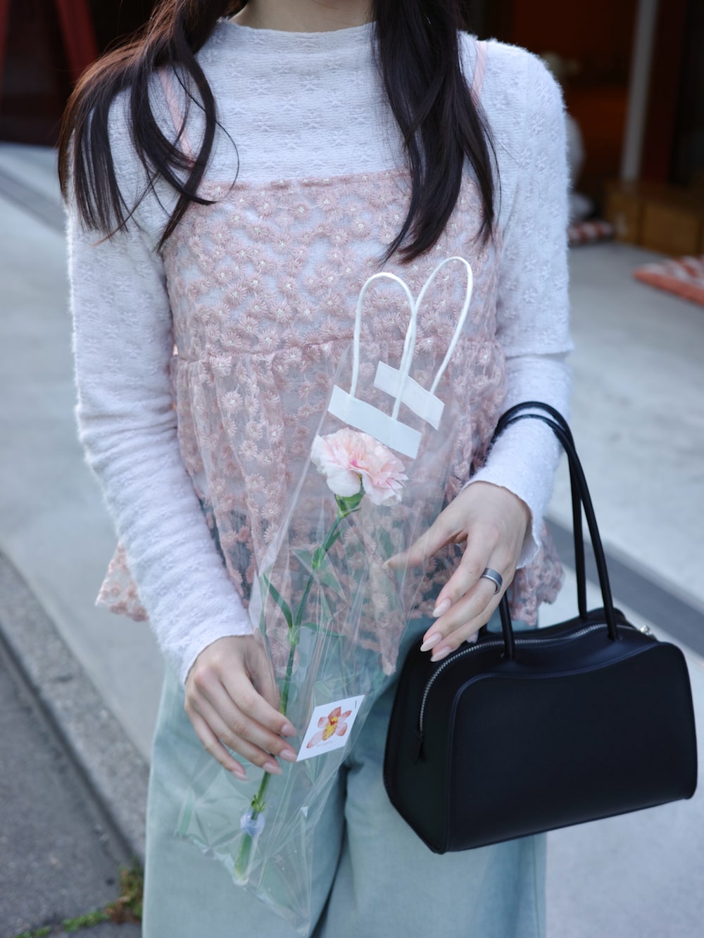ブラック系のショルダーバッグ、ブルー系のデニムパンツ、ブラック系のローファーを着用したレディースの春コーディネートの4枚目の写真