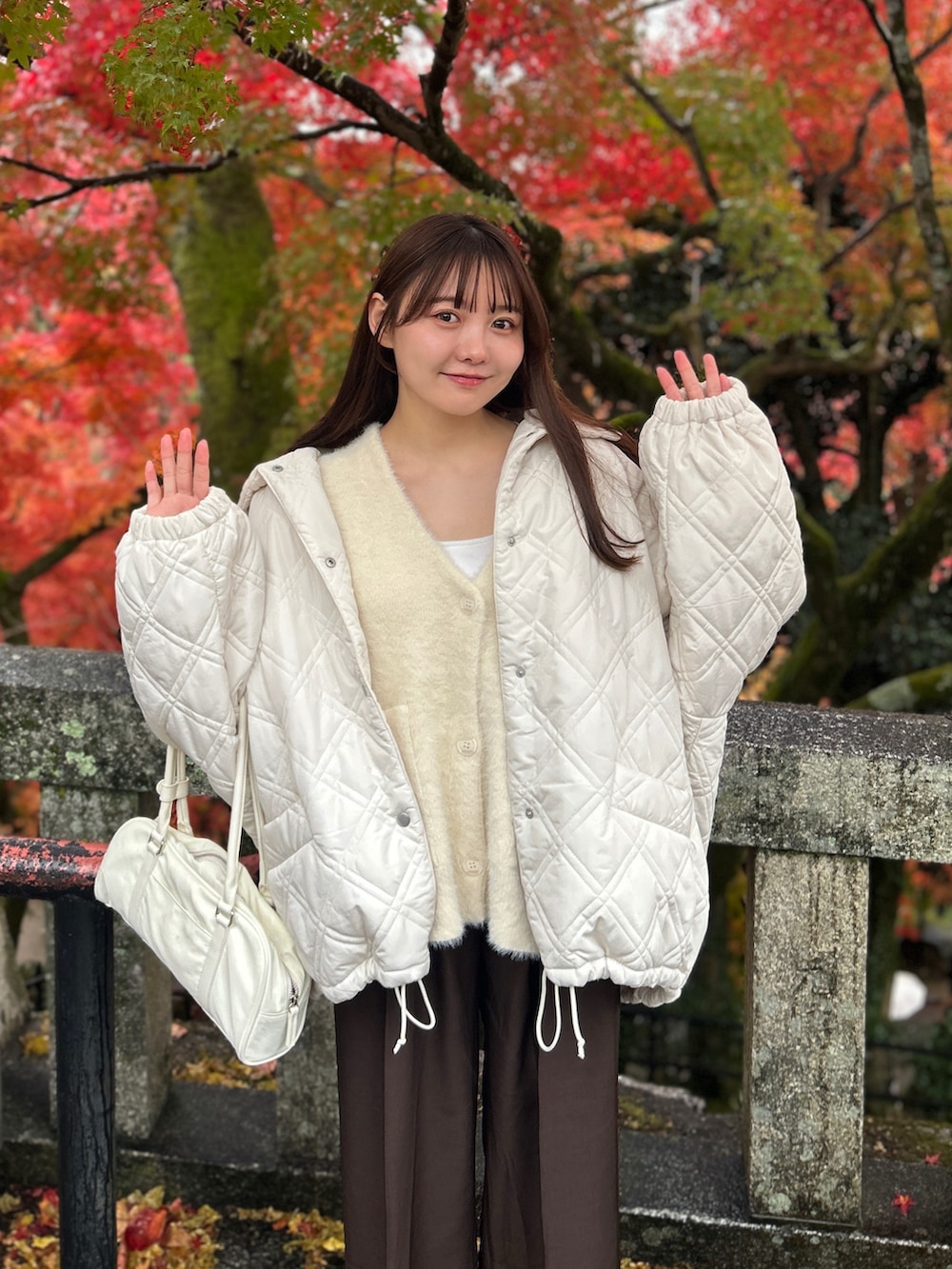 ホワイト系のブルゾン、ホワイト系のカーディガン/ボレロ、ホワイト系のキャミソールを着用したレディースの冬コーディネートの3枚目の写真