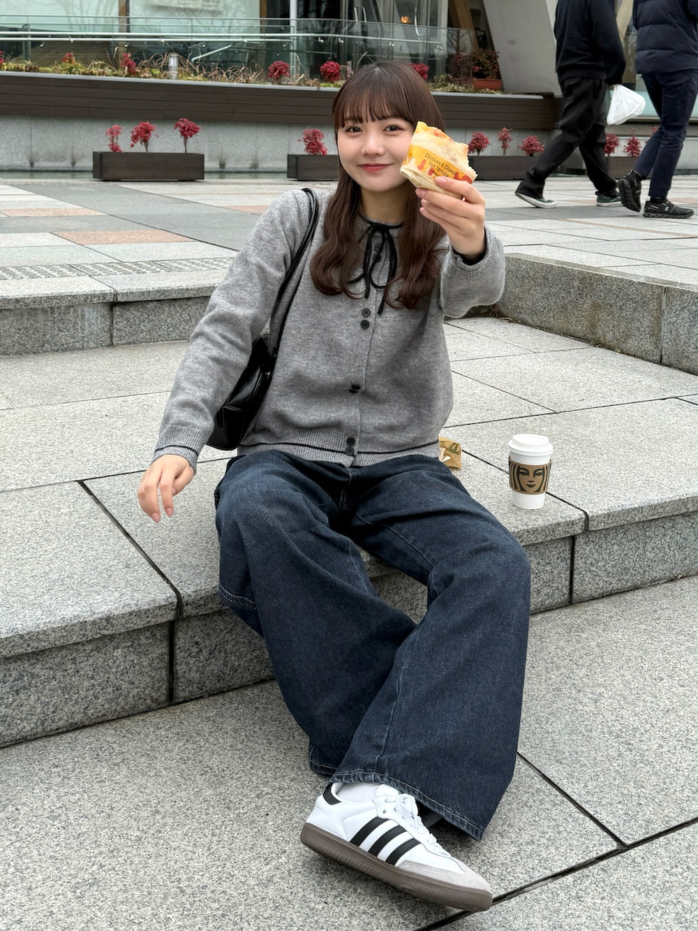 イエロー系のブーツ、ブラック系のダウンジャケット/コート、ブラック系のショルダーバッグを着用したレディースの冬コーディネートの2枚目の写真