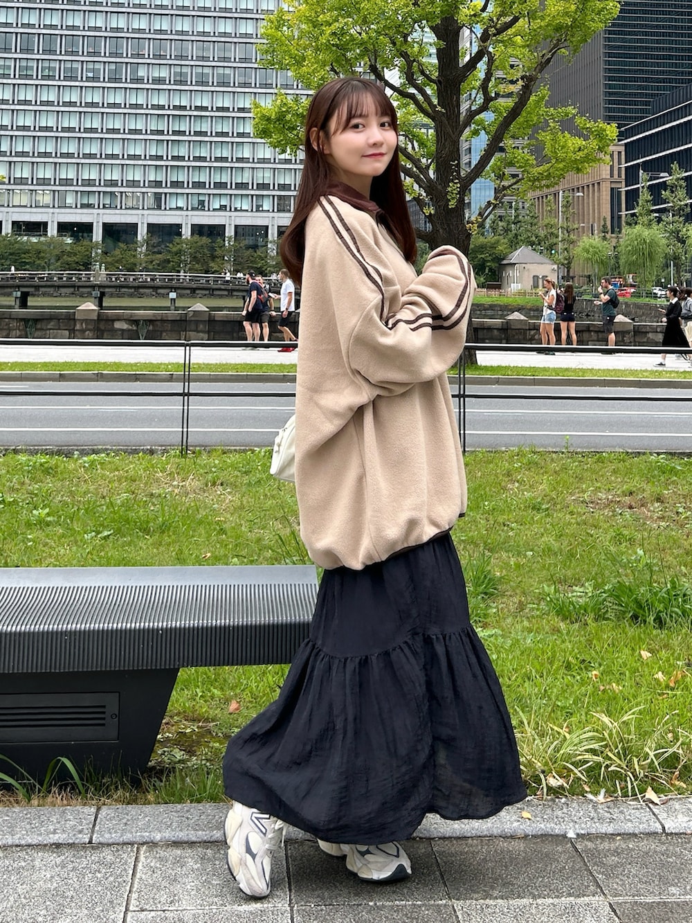 ブラウン系のスウェット、ホワイト系のバッグ、ブラック系のスカートを着用したレディースの秋コーディネートの2枚目の写真