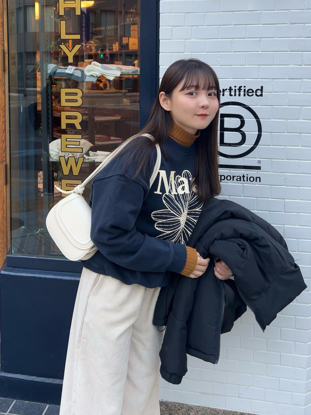 ブラック系のダウンジャケット/コート、ホワイト系のパンツ、イエロー系のブーツを着用したレディースの冬コーディネートの2枚目の写真