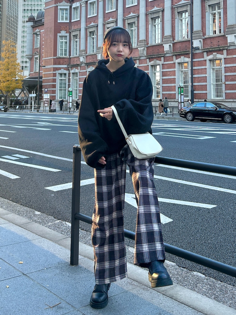 ブラック系のパーカー、ホワイト系のハンドバッグ、ブラウン系のその他パンツを着用したレディースの冬コーディネートの2枚目の写真