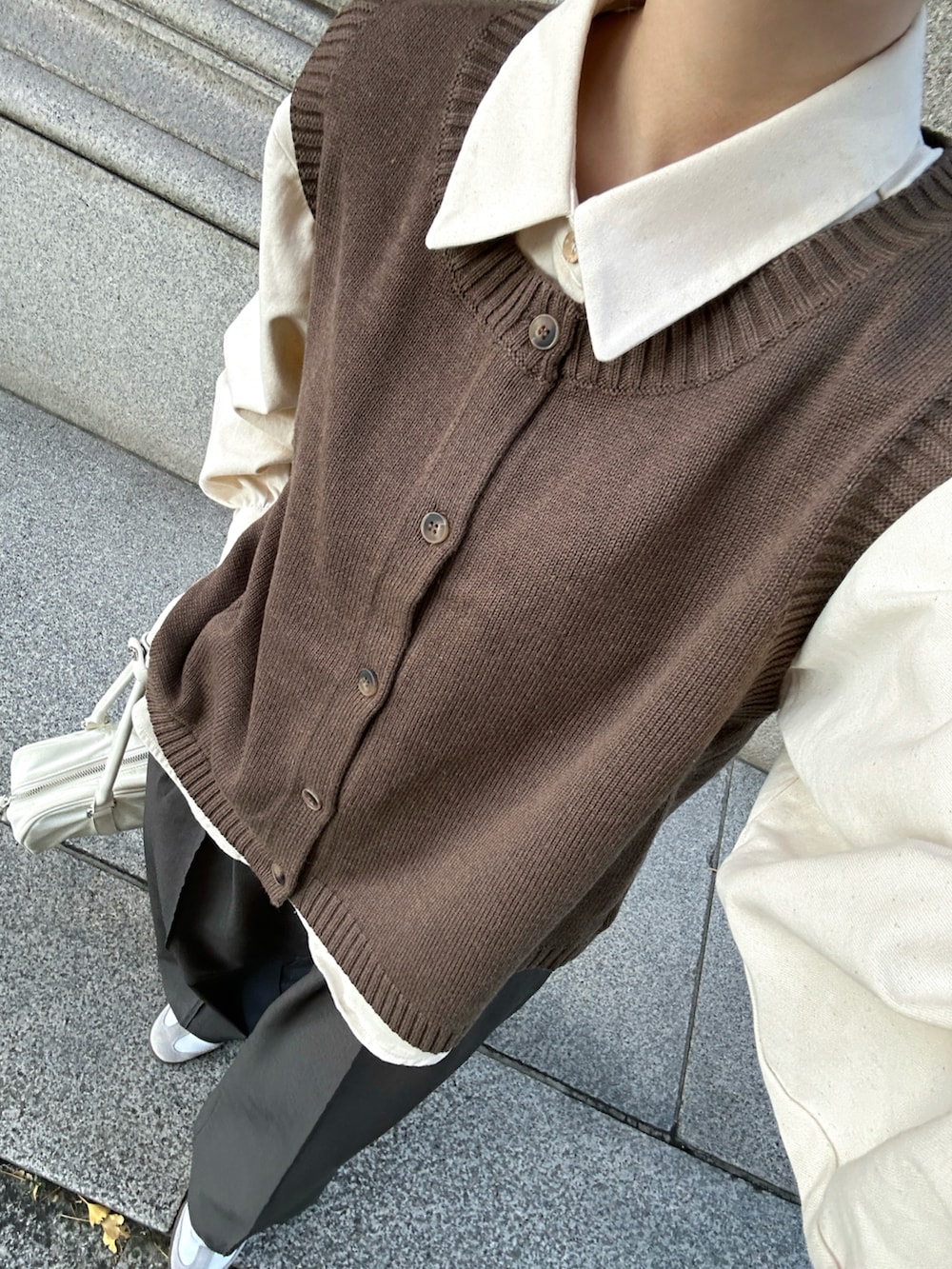 ベージュ系のシャツ/ブラウス、ブラウン系のトレンチコート、ブラウン系のベストを着用したレディースの冬コーディネートの2枚目の写真