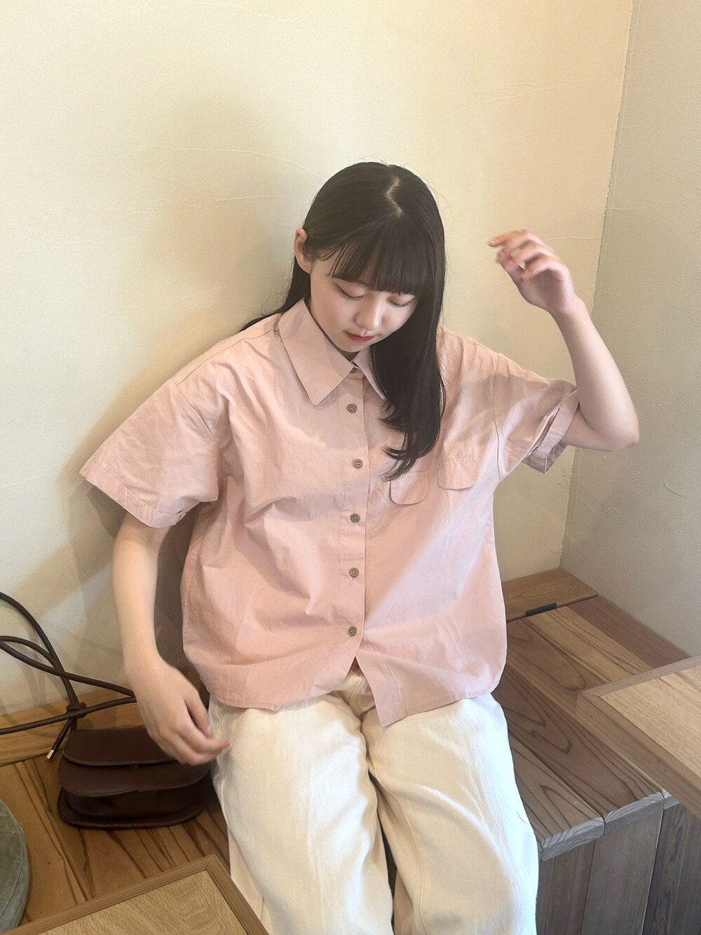 ピンク系のシャツ/ブラウス、ブラウン系のハンドバッグ、ホワイト系のパンツを着用したレディースの夏コーディネートの4枚目の写真