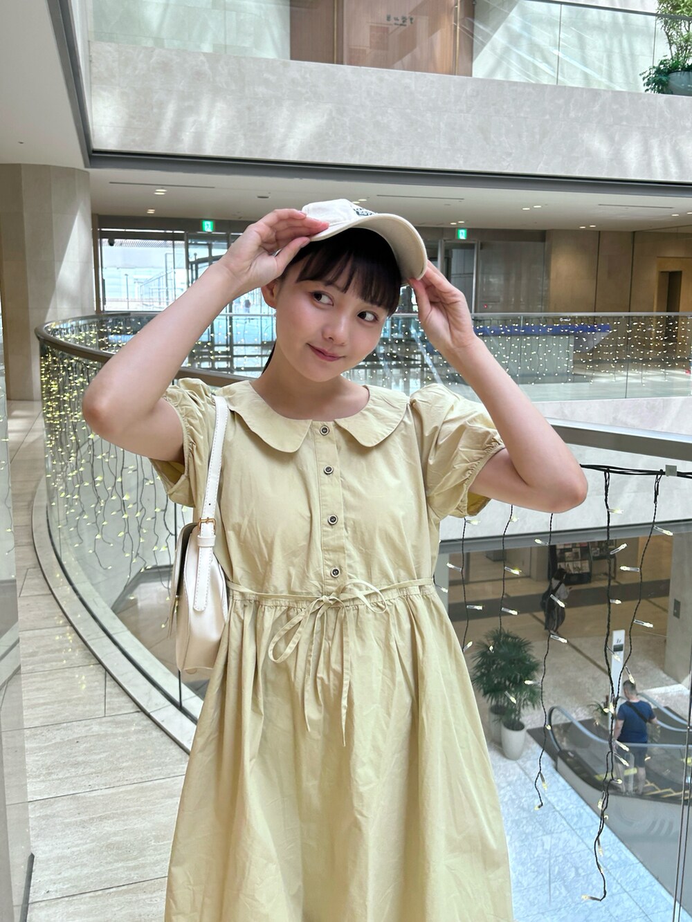 グリーン系のワンピース、ホワイト系のスニーカー、ホワイト系のソックス/靴下を着用したレディースの夏コーディネートの2枚目の写真