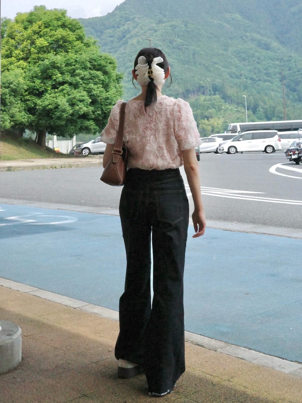 ピンク系のシャツ/ブラウス、ブルー系のデニムパンツ、ピンク系のスニーカーを着用したレディースの夏コーディネートの2枚目の写真