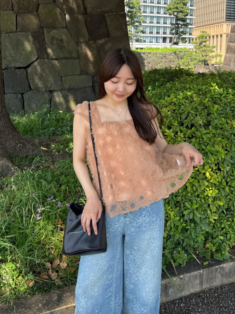 ピンク系のシャツ/ブラウス、ブルー系のデニムパンツ、ブラック系のショルダーバッグを着用したレディースの夏コーディネートの2枚目の写真