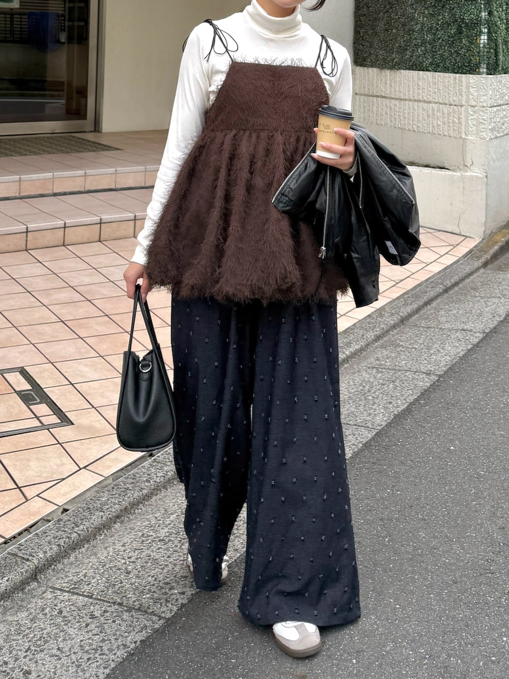 ブラウン系のキャミソール、ホワイト系のニット/セーター、ブラック系のブルゾンを着用したレディースの秋コーディネートの2枚目の写真