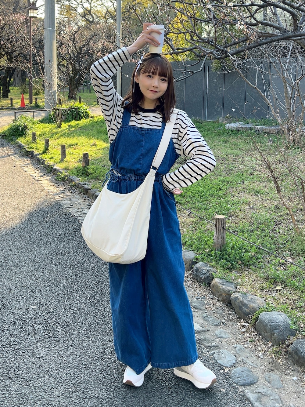 ホワイト系のTシャツ/カットソー、ホワイト系のショルダーバッグ、ブルー系のサロペット/オーバーオールを着用したレディースの春コーディネートの5枚目の写真