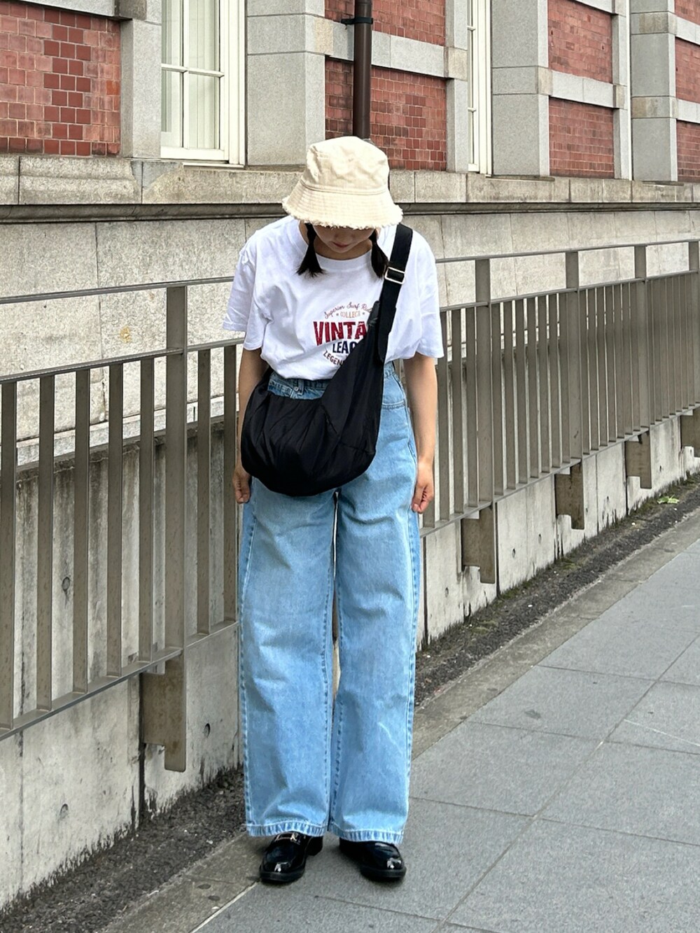 ブルー系のデニムパンツ、ブラック系のローファー、ホワイト系のTシャツ/カットソーを着用したレディースの春コーディネートの2枚目の写真