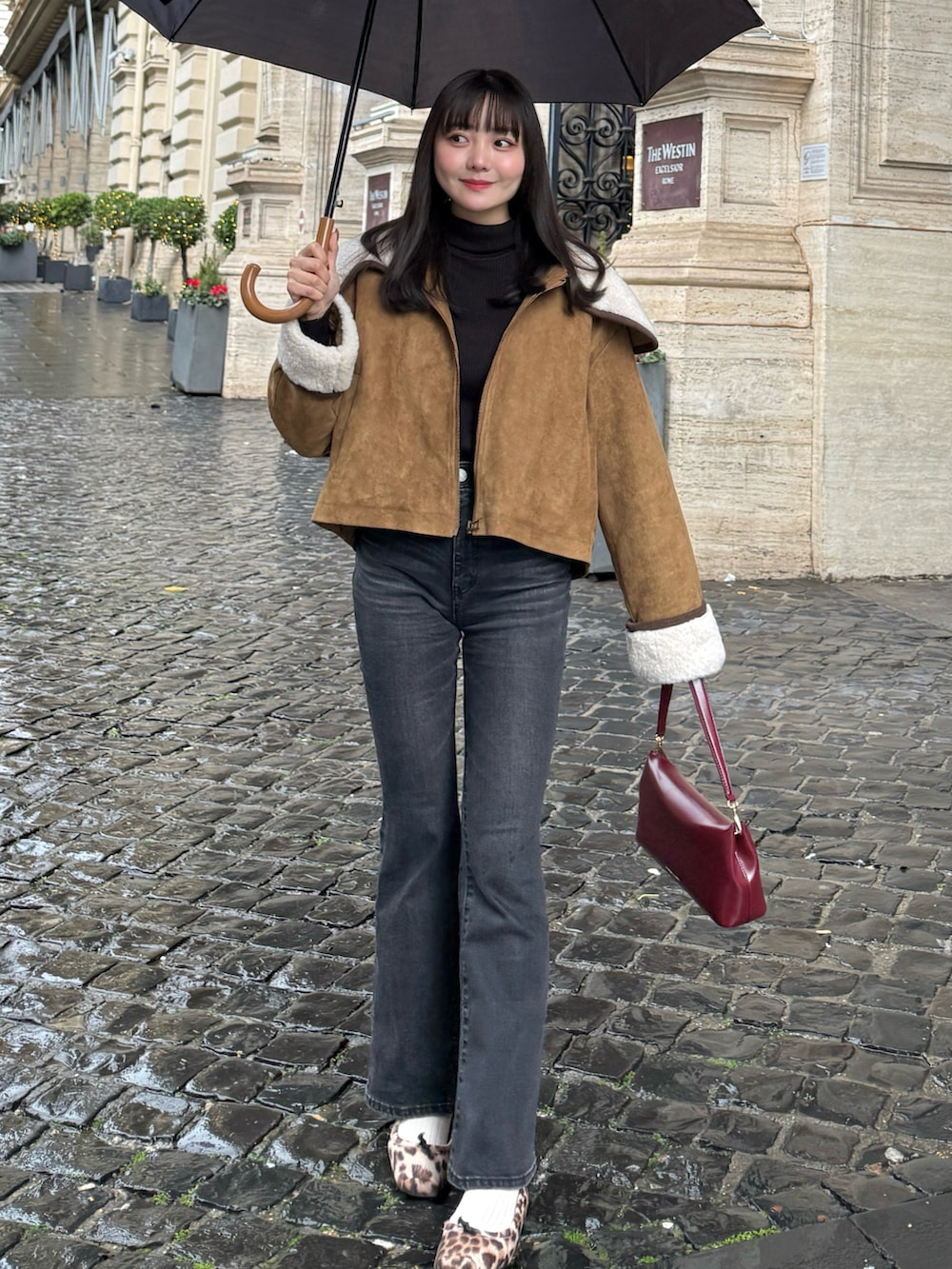 イエロー系のブルゾン、ブラック系のデニムパンツ、レッド系のショルダーバッグを着用したレディースの冬コーディネートの2枚目の写真