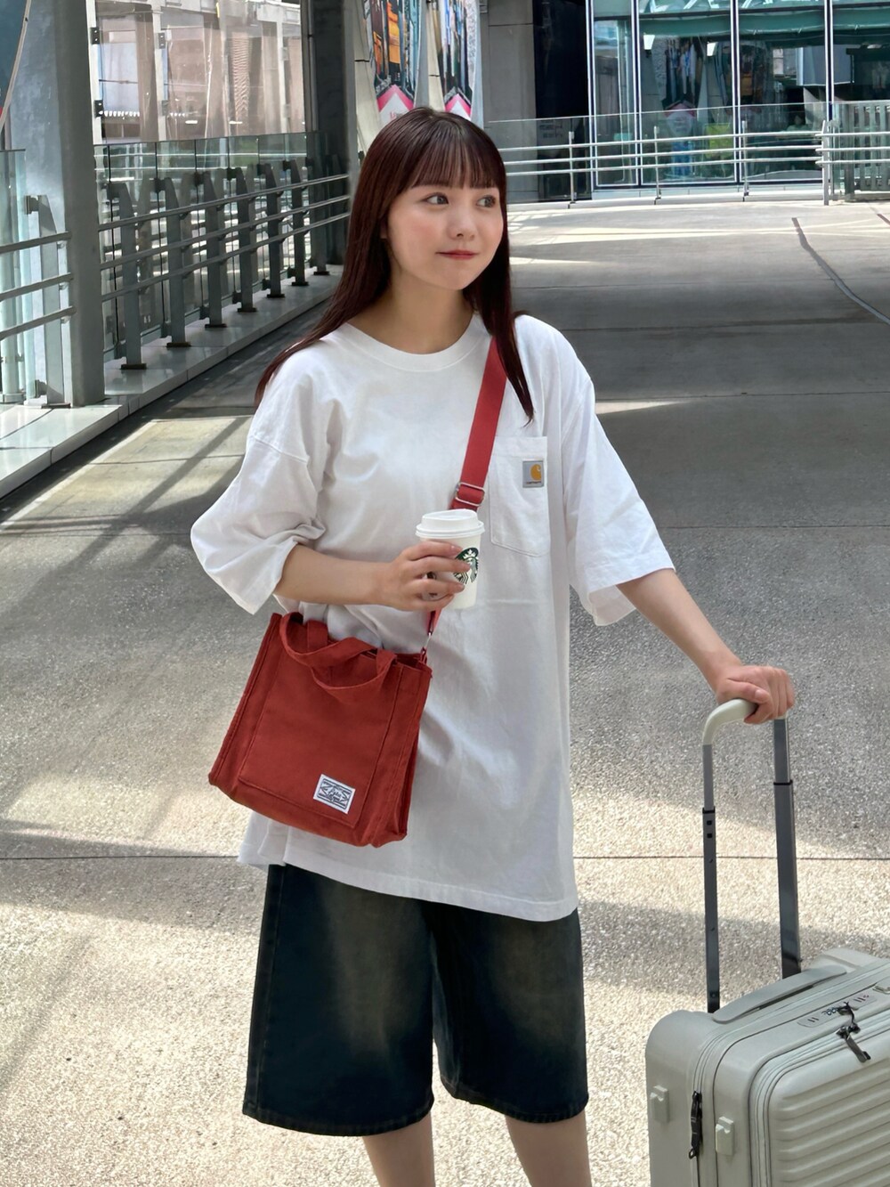 ホワイト系のTシャツ/カットソー、ブルー系のデニムパンツ、ホワイト系のスニーカーを着用したレディースの夏コーディネートの3枚目の写真