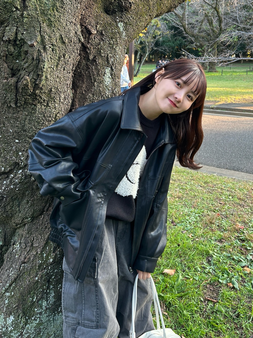 ブラック系のニット/セーター、ブラック系のブルゾン、グレー系のデニムパンツを着用したレディースの秋コーディネートの2枚目の写真