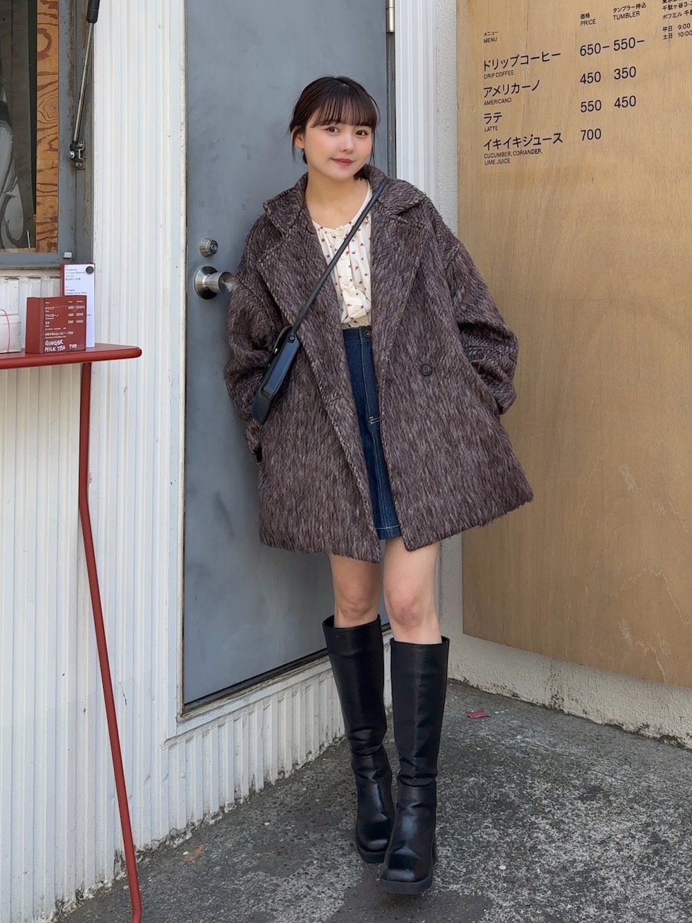 ブラウン系のピーコート、ブラック系のショルダーバッグ、ブラック系のブーツを着用したレディースの冬コーディネートの2枚目の写真