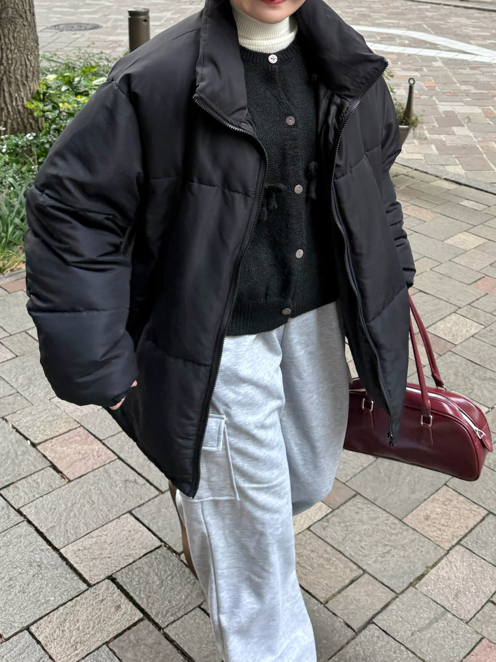 ブラック系のニット/セーター、ホワイト系のニット/セーター、レッド系のボストンバッグを着用したレディースの冬コーディネートの3枚目の写真