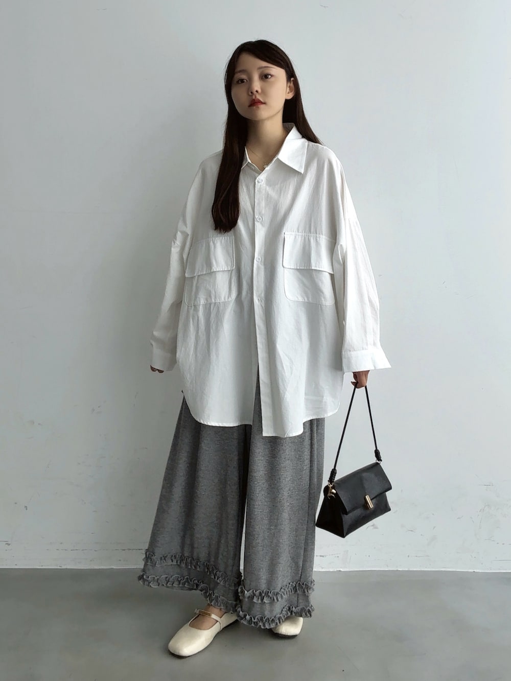 ホワイト系のシャツ/ブラウス、ブラウン系のショルダーバッグ、ホワイト系のパンプスを着用したレディースの秋コーディネートの4枚目の写真