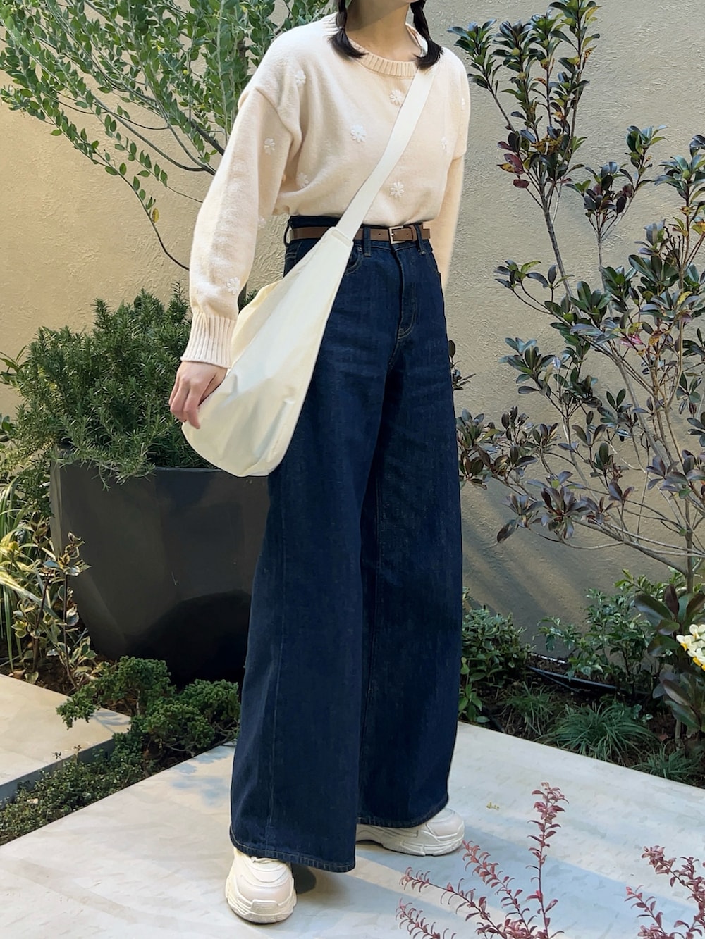 ホワイト系のノーカラージャケット、ブルー系のデニムパンツ、ホワイト系のスニーカーを着用したレディースの春コーディネートの5枚目の写真