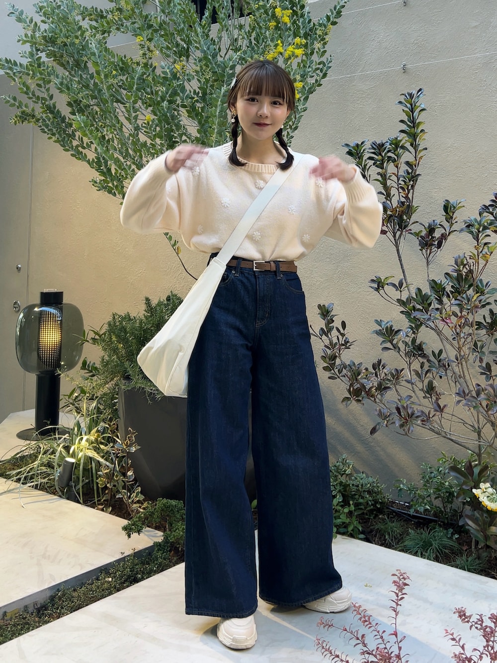 ホワイト系のノーカラージャケット、ブルー系のデニムパンツ、ホワイト系のスニーカーを着用したレディースの春コーディネートの4枚目の写真