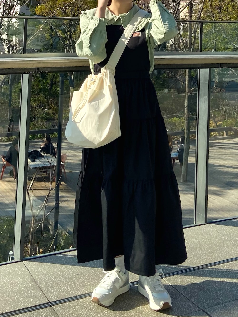 ブラック系のワンピース、ベージュ系のショルダーバッグ、グリーン系のシャツ/ブラウスを着用したレディースの春コーディネートの5枚目の写真