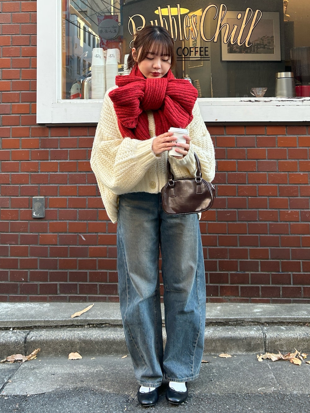 ホワイト系のカーディガン/ボレロ、ホワイト系のブルゾン、ブラウン系のハンドバッグを着用したレディースの冬コーディネートの2枚目の写真