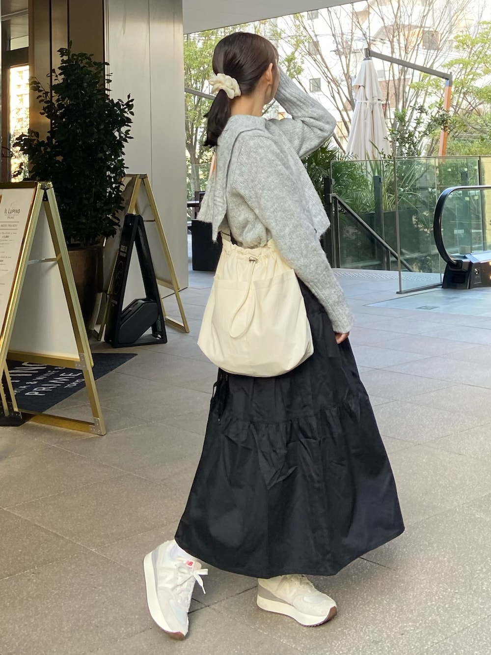 ブラック系のワンピース、グレー系のニット/セーター、ベージュ系のショルダーバッグを着用したレディースの春コーディネートの3枚目の写真