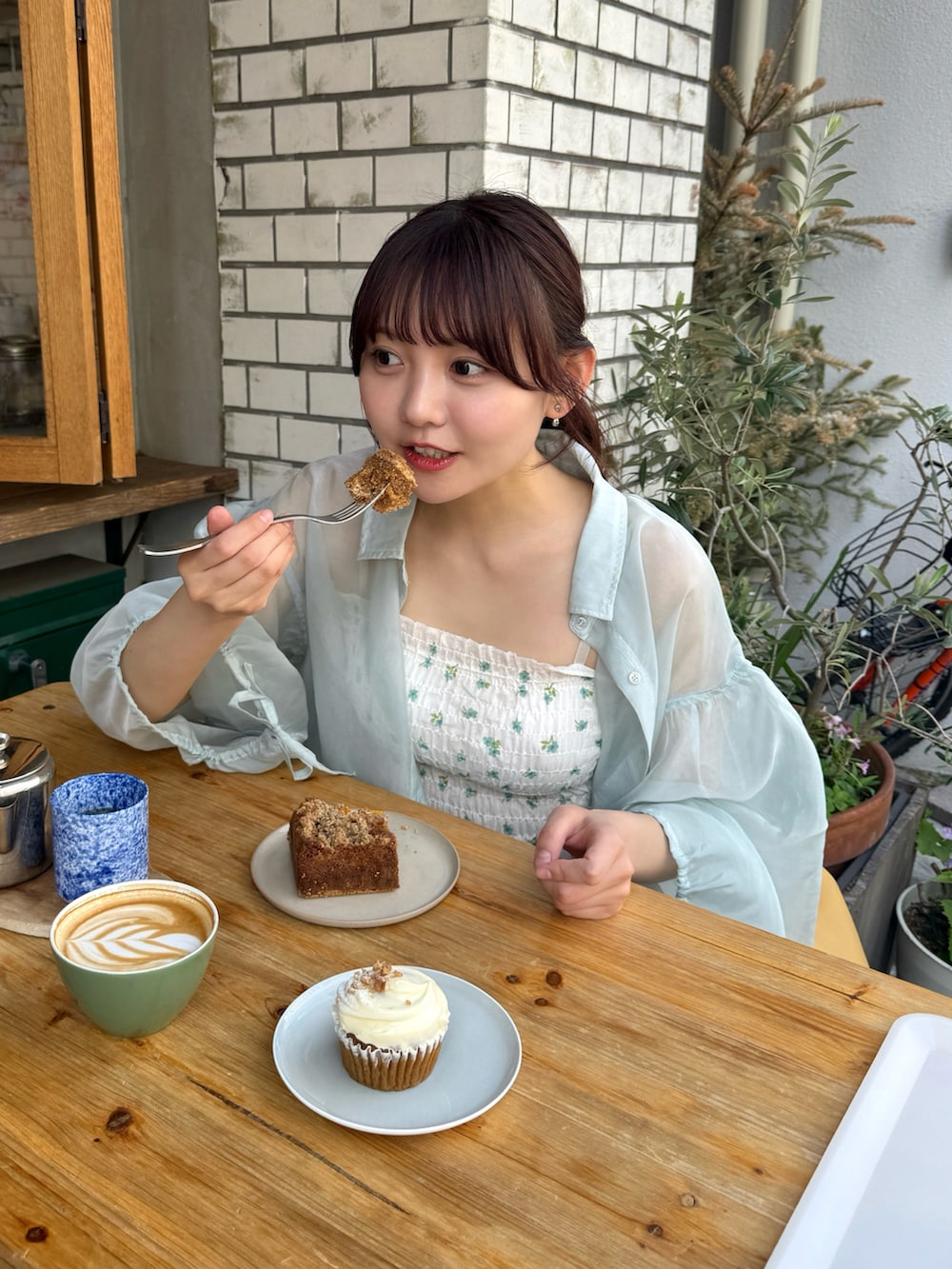 グリーン系のシャツ/ブラウス、イエロー系のハンドバッグ、ブルー系のデニムパンツを着用したレディースの夏コーディネートの2枚目の写真