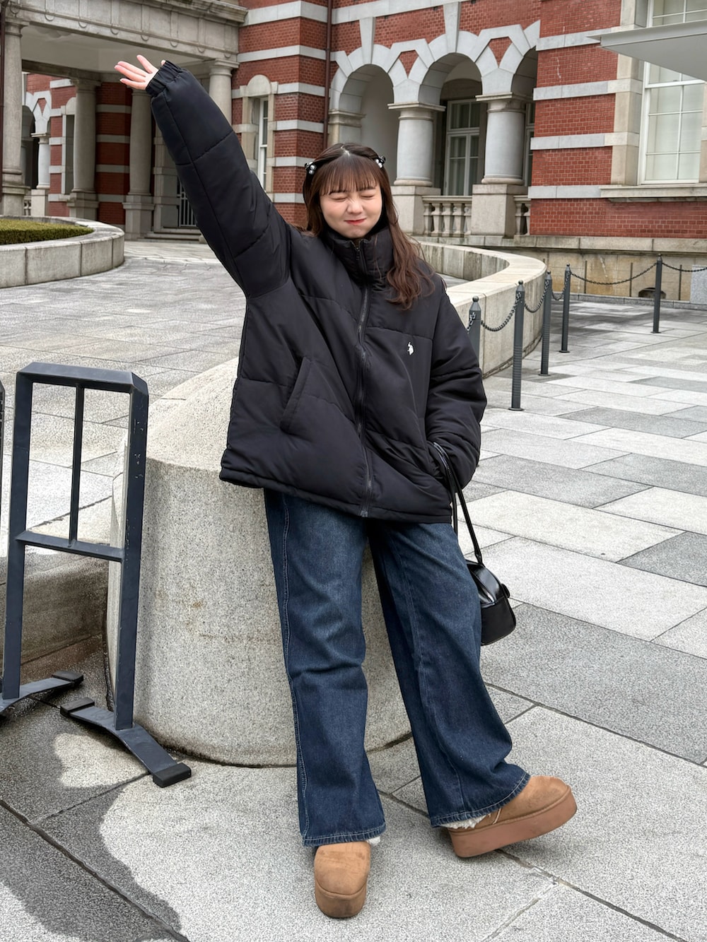 ブラック系のダウンジャケット/コート、ブルー系のデニムパンツ、イエロー系のブーツを着用したレディースの冬コーディネートの3枚目の写真