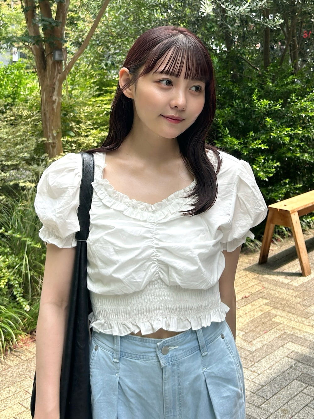 ホワイト系のシャツ/ブラウス、ブラック系のバッグ、ブルー系のデニムパンツを着用したレディースの夏コーディネートの2枚目の写真