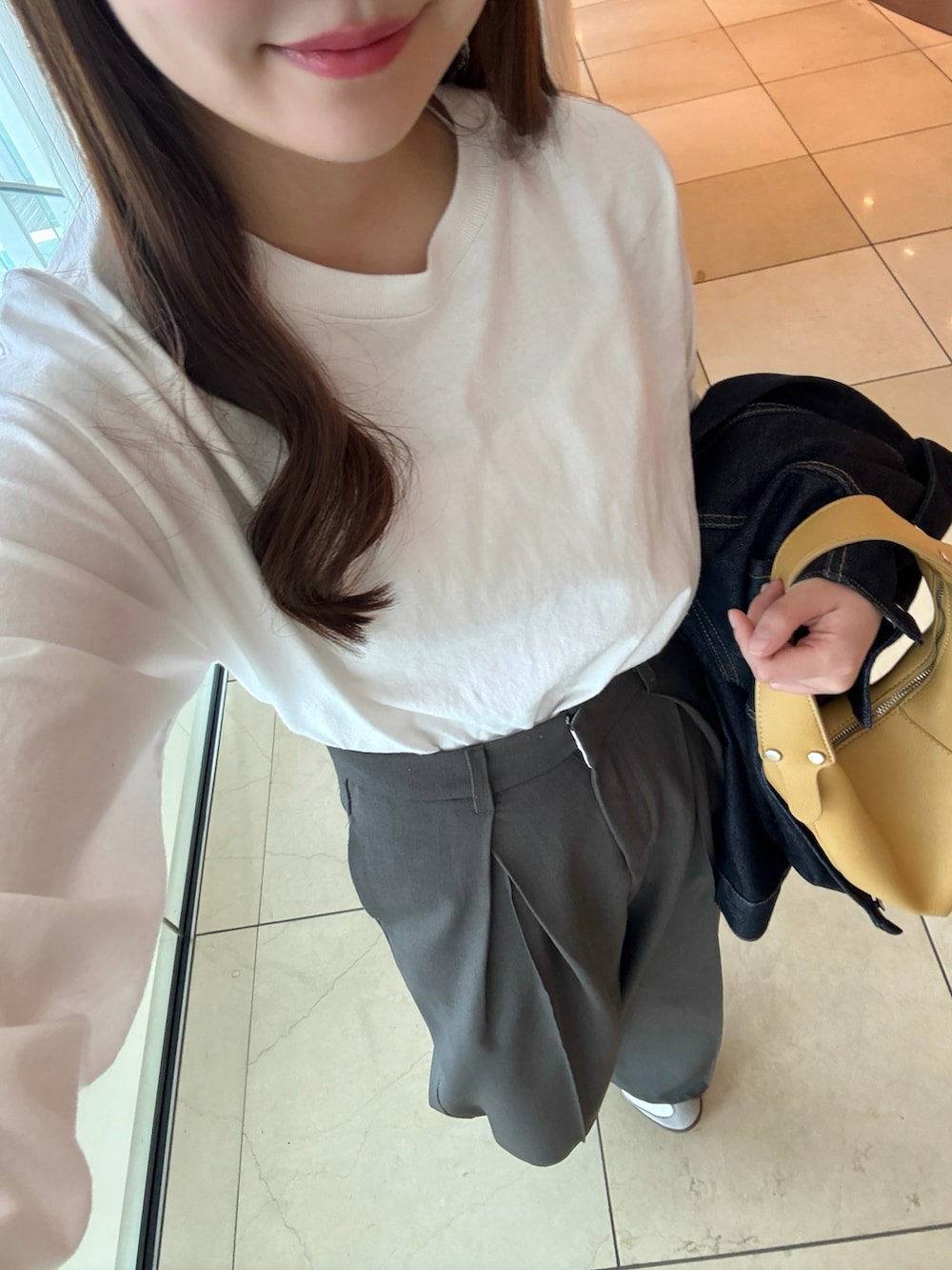 ホワイト系のTシャツ/カットソー、ブラック系のスラックス、ホワイト系のスニーカーを着用したレディースの春コーディネートの3枚目の写真