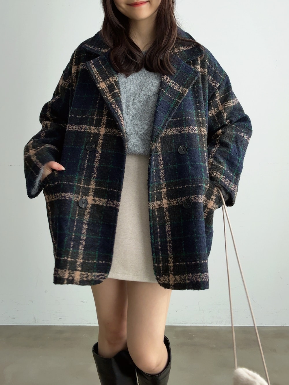 グレー系のニット/セーター、ホワイト系のスカート、ホワイト系のショルダーバッグを着用したレディースの冬コーディネートの5枚目の写真