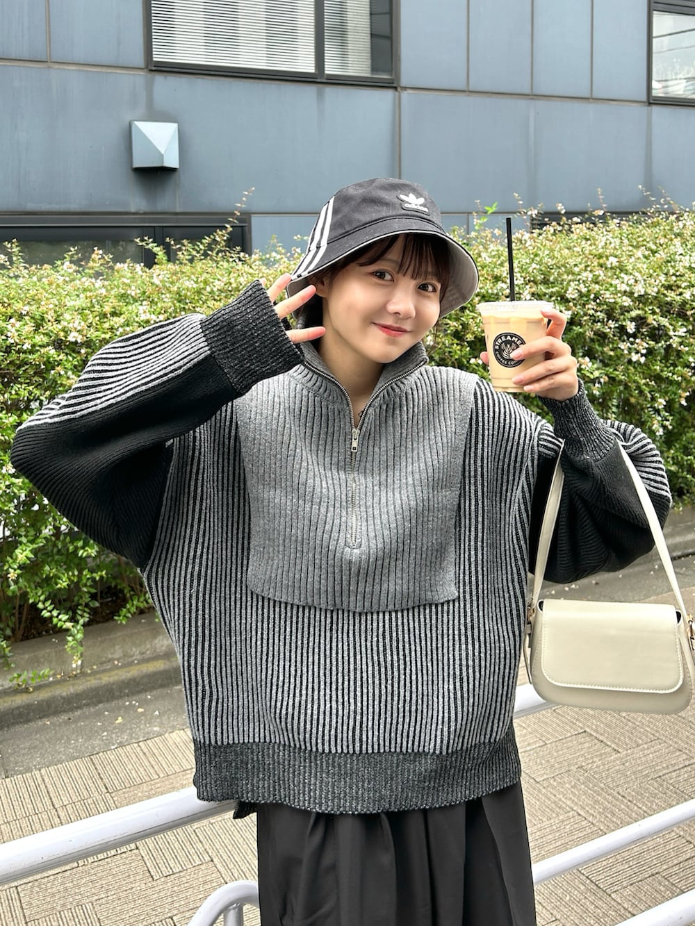 ブラック系のニット/セーター、ブラック系のスラックス、ホワイト系のスニーカーを着用したレディースの秋コーディネートの3枚目の写真